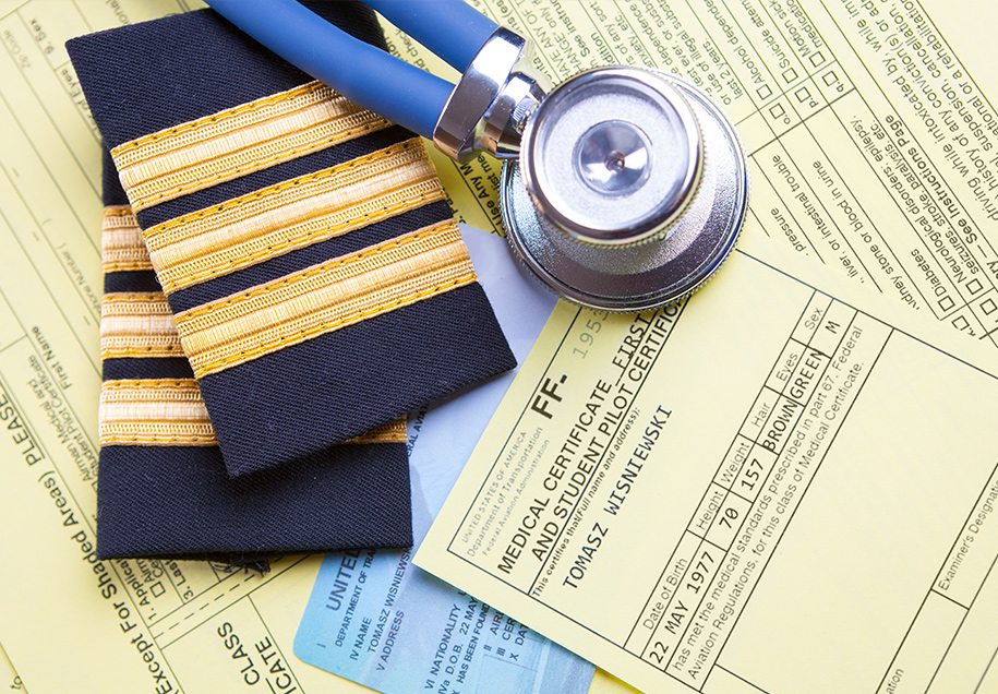 stethoscope and pilot epaulets resting on pilot medical forms