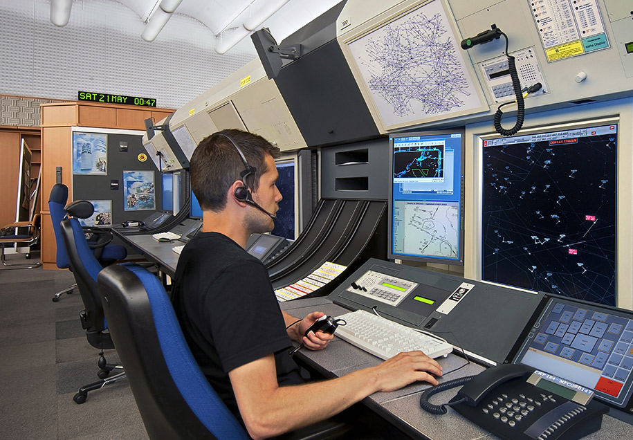 air traffic control officer with a headset directing flight traffic on his computer screen